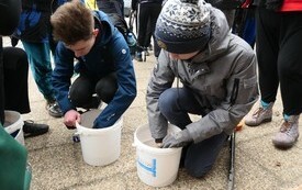 Młodzież miesza ziarno przed wysiewem