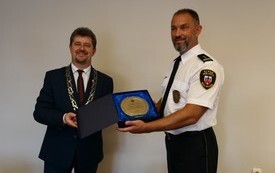 Burmistrz wręcza pamiątkową tablicę komendantowi straży miejskiej