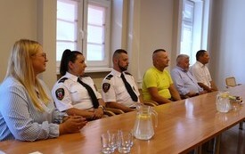 pracownicy Straży Miejskiej w Malborku siedzą przy stole