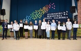 Grupowe zdjęcie stypensyst&oacute;w SP nr 2 przed sceną