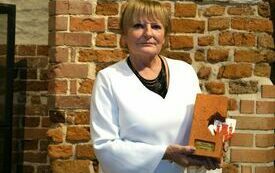 Teresa Żelazo prezentująca otrzymaną pamiątkową cegłę z herbem Malborka