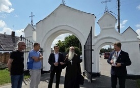Delegacja z polskim księdzem przed cmentarzem Ładomirskim