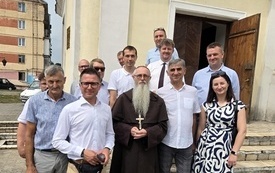 Zdjęcie uczestnik&oacute;w spotkania z polskim księdzem porzed kościołem