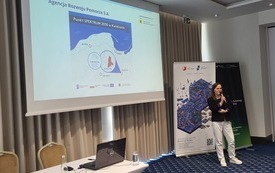 Prelegentka przy ekranie z prezentacją