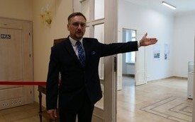 człowiek zapraszający do zwiedzania wystawy o Stalagu