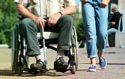 osoba na wózki inwalidzkim, obok idąca osoba