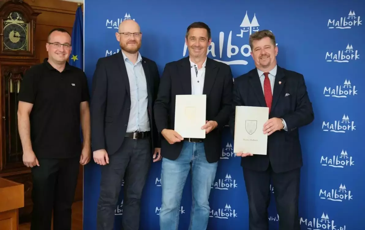 przedstawiciele firmy Strabag oraz burmistrz na tle napisów Malbork