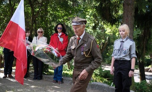 Harcerze składający kwiaty pod pomikiem